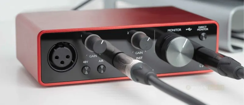 De audio interface - Essentieel voor professionele geluidskwaliteit | Muziekbundel.nl Close-up van een audio interface met aangesloten kabels, essentieel voor muziekproductie en live optredens.