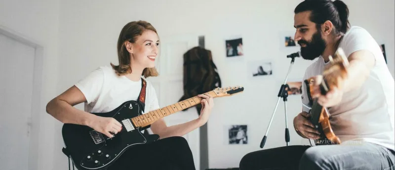 Samenspelen met anderen - Ontdek de magie van samen muziek maken - Muziekbundel.nl Muzikanten die samen spelen op verschillende instrumenten zoals gitaar, piano en drums.